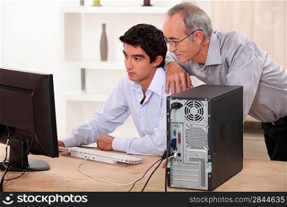 Grandfather and grandson looking at the computer