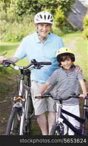 Grandfather And Grandson On Cycle Ride In Countryside