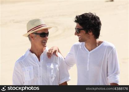 Grandfather and grandson on the beach