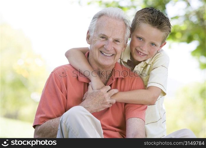 Grandfather and grandson outdoors smiling