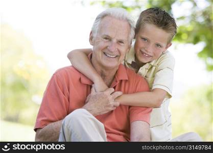 Grandfather and grandson outdoors smiling