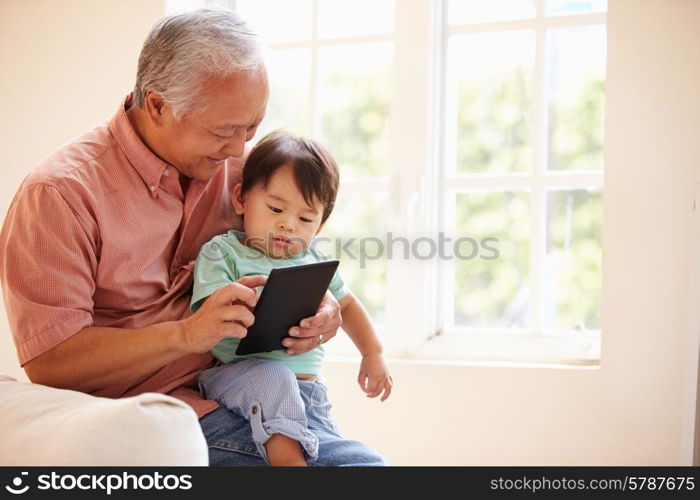 Grandfather And Grandson Using Digital Tablet Together