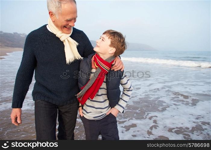 Grandfather And Grandson Walking On Winter Beach