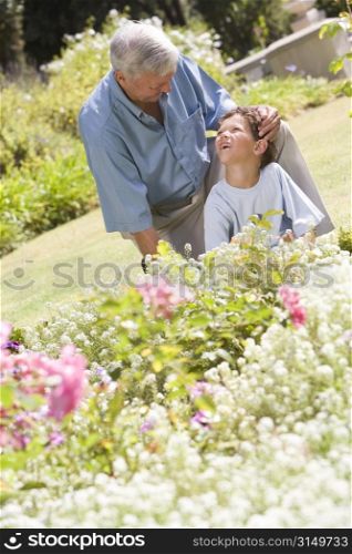 Grandfather and grandson working in the garden.