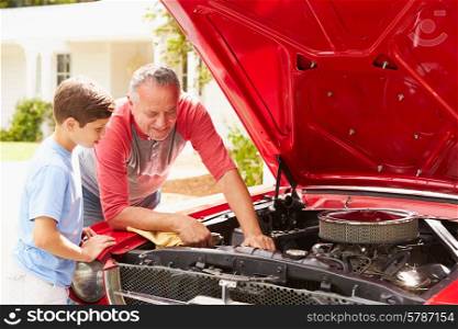 Grandfather And Grandson Working On Restored Classic Car