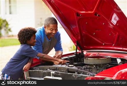 Grandfather And Grandson Working On Restored Classic Car