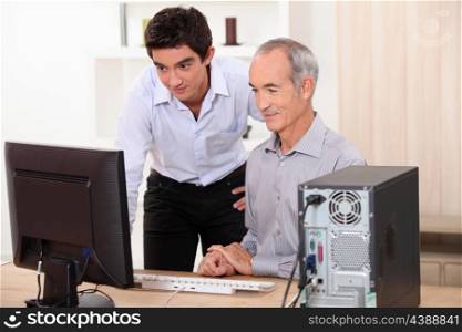 grandfather and grandson working together on a computer