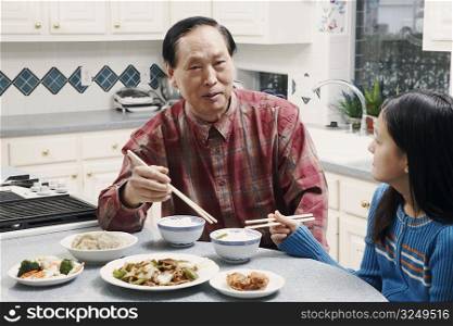 Grandfather and his granddaughter sitting at a table