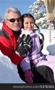 Grandfather and little girl in ski holidays