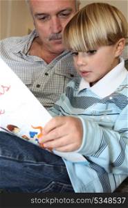 Grandfather and son reading