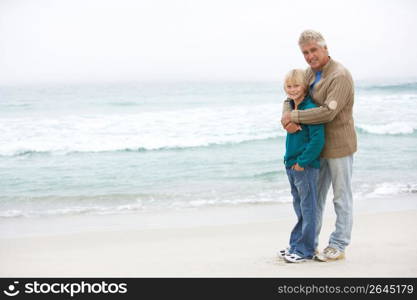Grandfather And Son Standing On Winter Beach Together