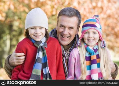 Grandfather and two children outdoors in park smiling (selective focus)