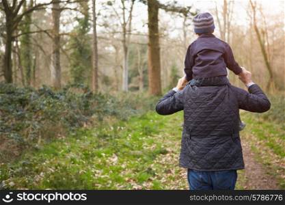 Grandfather Carrying Grandson On Shoulders During Walk