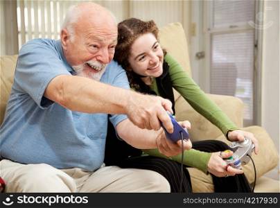 Grandfather enjoys playing video games with his teenage granddaughter.