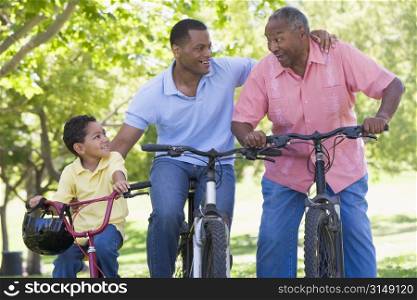 Grandfather grandson and son bike riding.