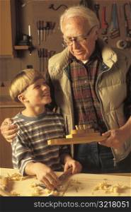 Grandfather Helping Grandson in Wood Shop