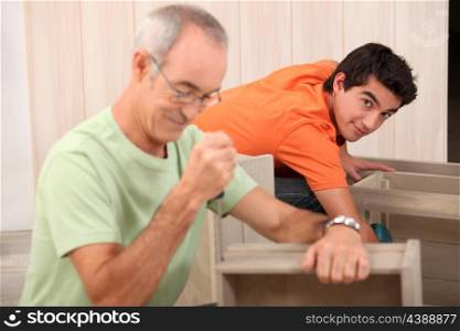Grandfather helping grandson with the furniture