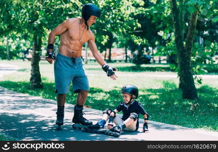 Grandfather helping his grandson after roller skating accident