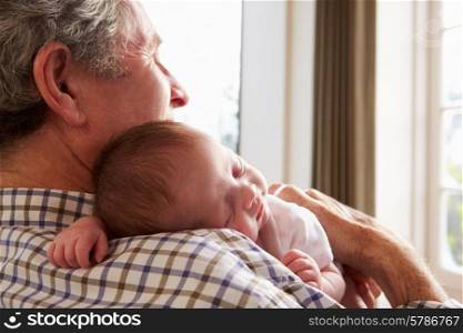 Grandfather Holding Sleeping Newborn Baby Granddaughter