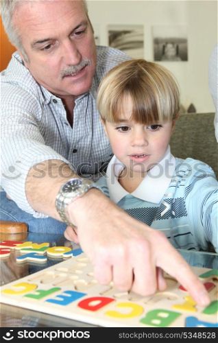 grandfather learning his grandson to read