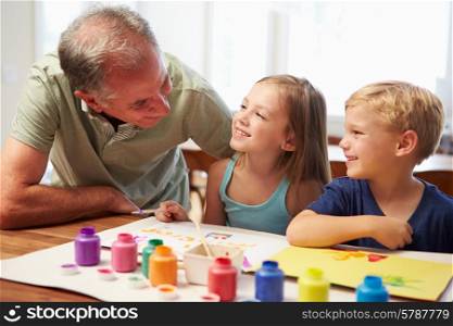 Grandfather Painting Picture With Grandchildren At Home
