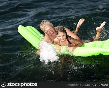 Grandfather playing with girl in water
