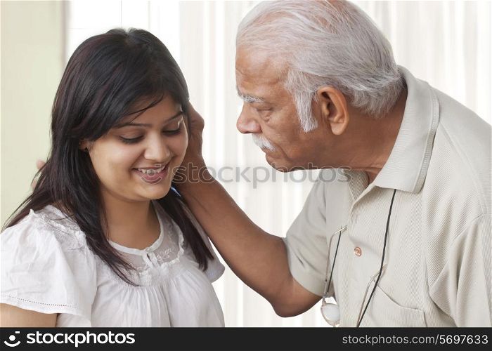 Grandfather pulling ears of granddaughter