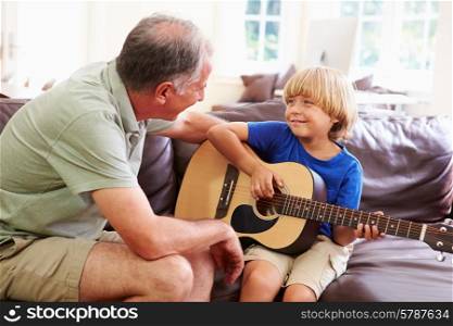 Grandfather Teaching Grandson To Play Guitar