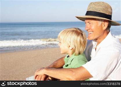Grandfather with child on beach relaxing