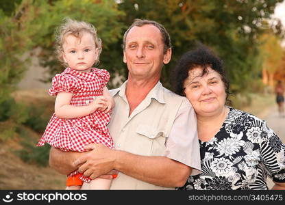 Grandfather with granddaughter on hands and by grandmother