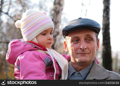 Grandfather with granddaughter on hands outdoor