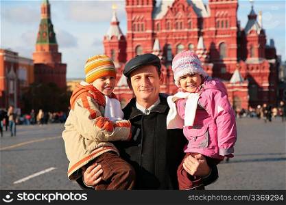 Grandfather with grandson and granddauther on red square