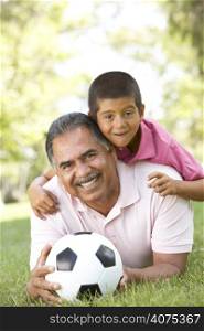 Grandfather With Grandson In Park With Football