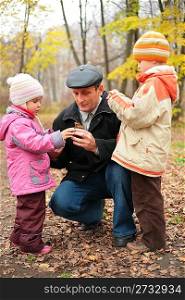 Grandfather with grandsons in forest in autumn, focus on senior