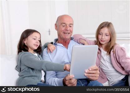 Grandfather with kids using electronic tablet