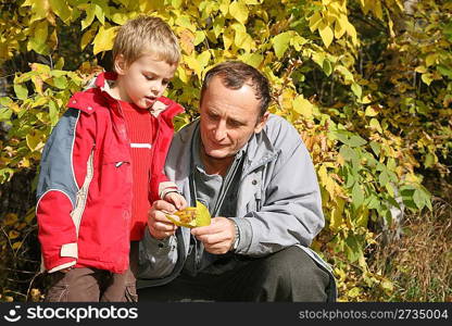 grandfather with the grandson in the park in autumn