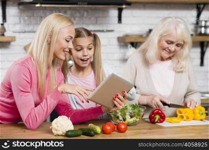 grandma is cooking women are using tablet