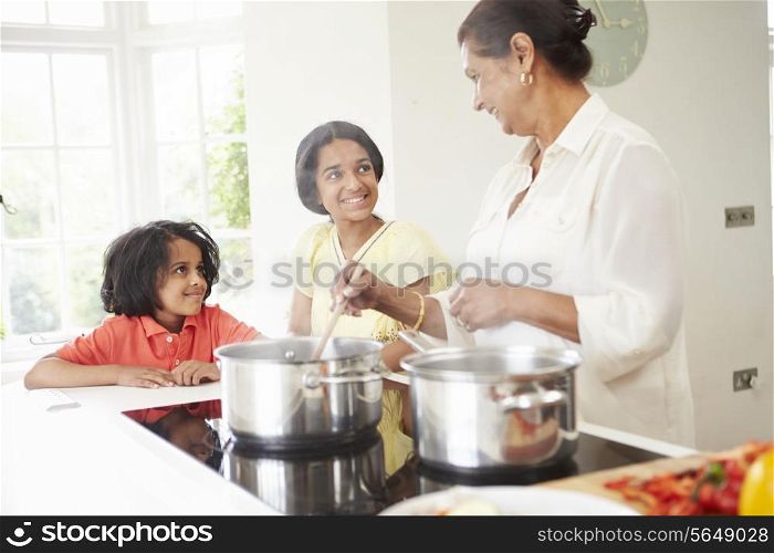 Grandmother And Grandchildren Cooking Meal At Home