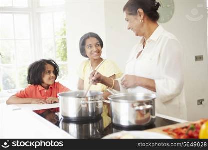 Grandmother And Grandchildren Cooking Meal At Home