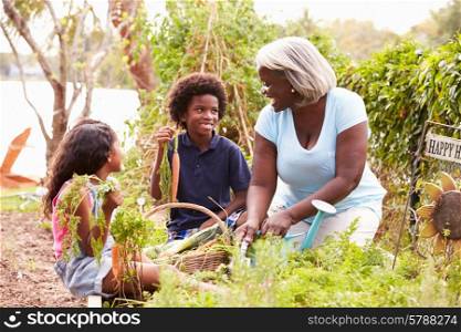 Grandmother And Grandchildren Working On Allotment