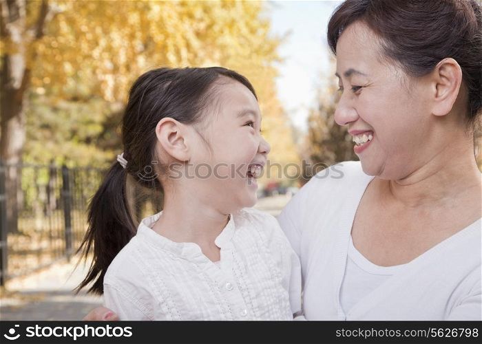 Grandmother and Granddaughter Enjoying the Park in Autumn