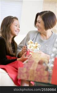 Grandmother And Granddaughter Exchanging Christmas Gifts