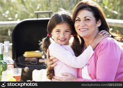 Grandmother And Granddaughter Having Outdoor Barbeque