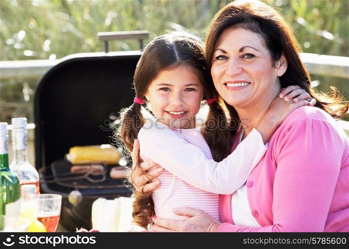 Grandmother And Granddaughter Having Outdoor Barbeque