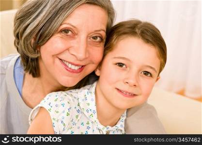 Grandmother and granddaughter hugging together smiling close-up portrait