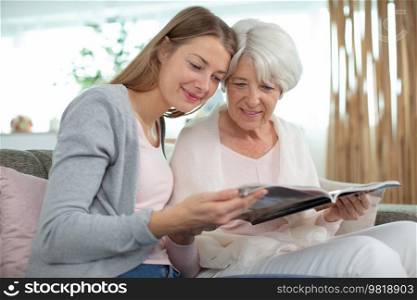 grandmother and granddaughter looking at magazine