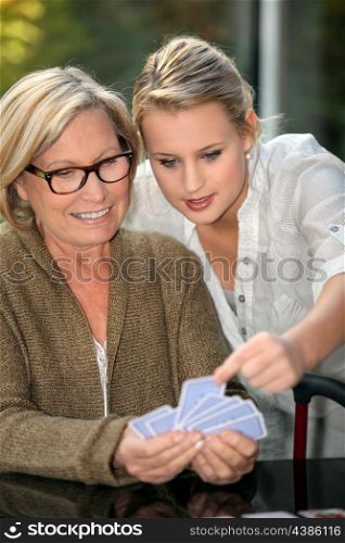 Grandmother and granddaughter playing cards
