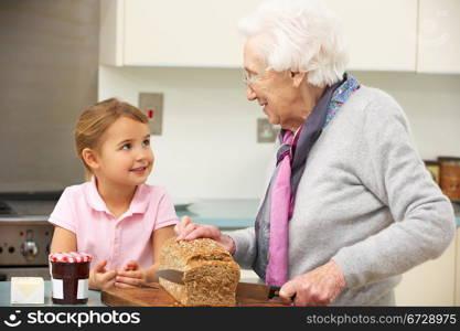 Grandmother and granddaughter preparing food in kitchen