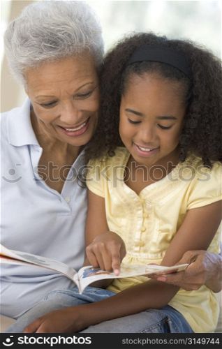 Grandmother and granddaughter reading and smiling