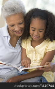 Grandmother and granddaughter reading and smiling